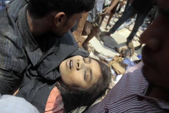 Rescue workers pull a woman out from the rubbles after an eight-story building housing several garment factories collapsed in Savar, near Dhaka, Bangladesh.