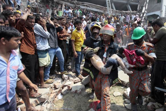 Rescue workers carry a young victim`s body after an eight-story building housing several garment factories collapsed in Savar, near Dhaka, Bangladesh.