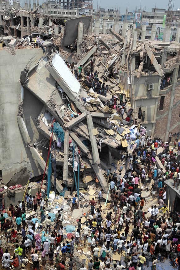 People and rescuers gather after an eight-story building housing several garment factories collapsed in Savar, near Dhaka, Bangladesh.