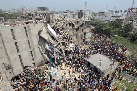 People and rescuers gather after an eight-story building housing several garment factories collapsed in Savar, near Dhaka, Bangladesh. Dozens were killed and many more are feared trapped in the rubble.