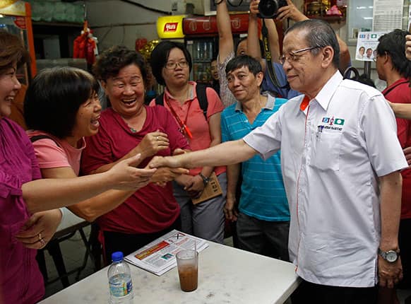 Malaysia`s opposition Democratic Action Party leader Lim Kit Siang, right, shakes hand with supporters during an election campaign in Puchong, near Kuala Lumpur, Malaysia.