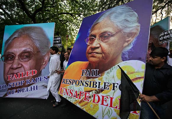 Activists of India`s main opposition Bharatiya Janata Party shout slogans demanding the resignation of Delhi Chief Minister Sheila Dikshit, portraits seen, as they participate in a torch light procession against the rape of a 5-year-old girl in New Delhi.
