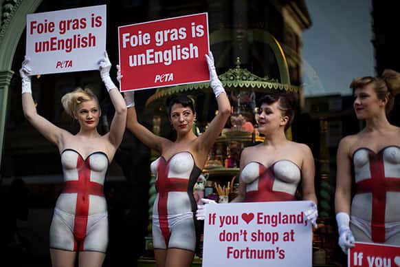 Supporters of PETA (People for the Ethical Treatment of Animals), wearing body paint in the design of the Union flag, hold placards protesting against Foie gras being sold by the Fortnum & Mason department store outside the premises in London.