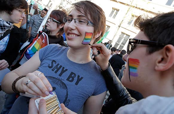 Pro gay marriage activists paint gay colors on their cheeks after French lawmakers legalized same-sex marriage, in Paris.