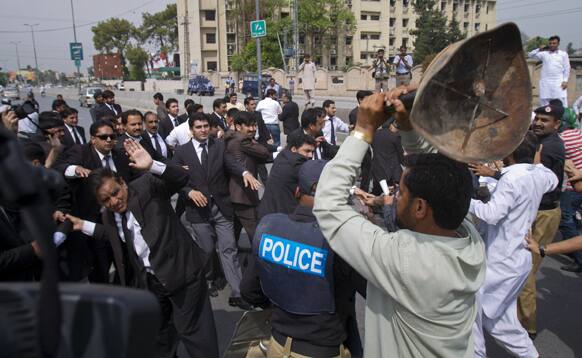 Supporters of Pakistan`s former President and military ruler Pervez Musharraf scuffle with lawyers outside an anti-terrorism court, where Musharraf appeared in Rawalpindi, Pakistan.