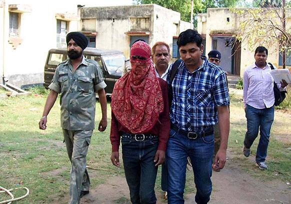 Pradeep Kumar, a 19-year-old garment factory worker, face covered is taken away by police after he was arrested in Lakhisarai District, Bihar state.
