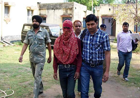 Pradeep Kumar, a 19-year-old garment factory worker, face covered is taken away by police after he was arrested in Lakhisarai District, Bihar state.