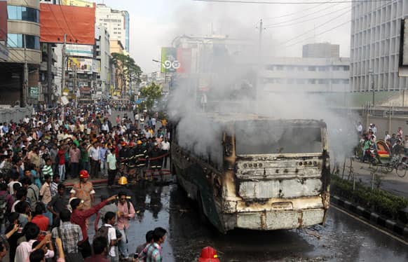 Bangladeshi fire fighters try to douse the fire on a bus set ablaze during a protest by opposition activists in Dhaka, Bangladesh.