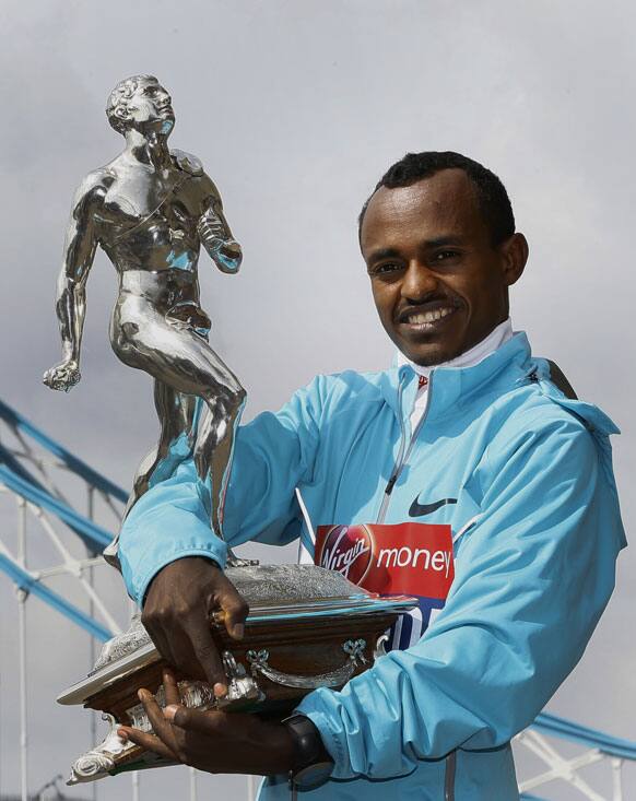 Winner of the men`s 2013 London Marathon Tsegaye Kebede of Ethiopia holds the trophy at a photocall by Tower Bridge in London.