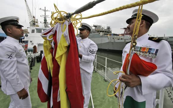 Coast Guard personnels check flags prior to a ceremony at commissioning of a high speed inshore patrol vessel at Rajdood in Kolkata. The ship has maximum speed of 34 knots with water jet propulsion, fitted with a 30 mm gun on front deck, a press release said.