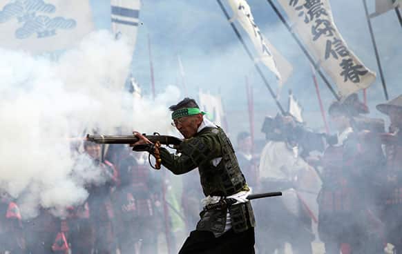 A matchlock gun preservation society member shoots a firearm as he and others participate in a re-enactment of the Battle of Kawanakajima, which was fought in the mid 16th century, in Fuefuki, Yamanashi Prefecture, northeast of Tokyo.