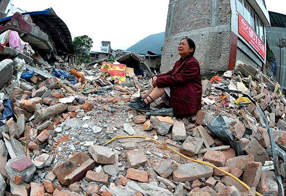 A woman whose relatives were killed in Saturday`s earthquake cries while sitting on a pile of rubble in Lingguan township in Baoxing county of southwest China`s Sichuan province.