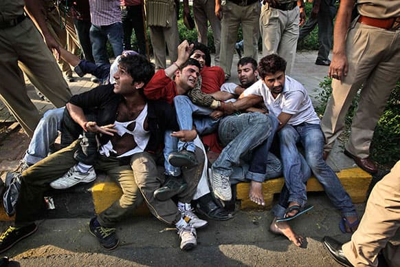 Indian protestors huddle together and shout slogans as police try to remove them from outside the prime minister`s residence during a protest against the rape of a 5-year-old girl in New Delhi.