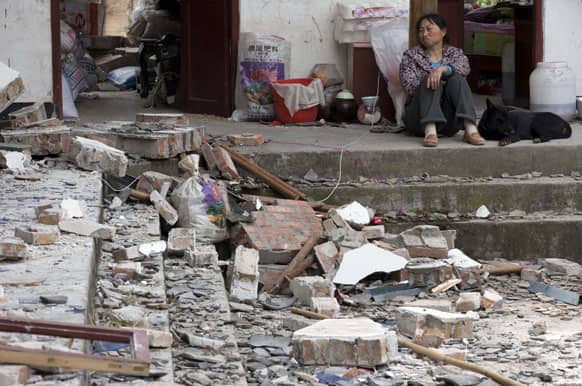 A woman looks over at her destroyed house in Gucheng village in Longmen county of southwestern China`s Sichuan province.