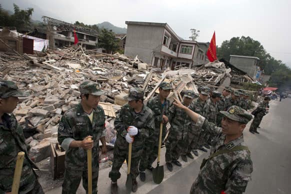 Rescue workers prepare to enter an area devastated by an earthquake in Gucheng village in Longmen county of southwestern China`s Sichuan province.