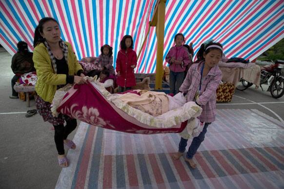 Residents pack away bedding after sleeping in an outdoor shelter near Shangli town in southwestern China`s Sichuan province.