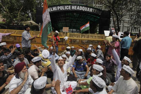 Protestors wave the Indian flag as they sit outside the Delhi Police Headquarters during a protest against the rape of a 5-year-old girl in New Delhi.