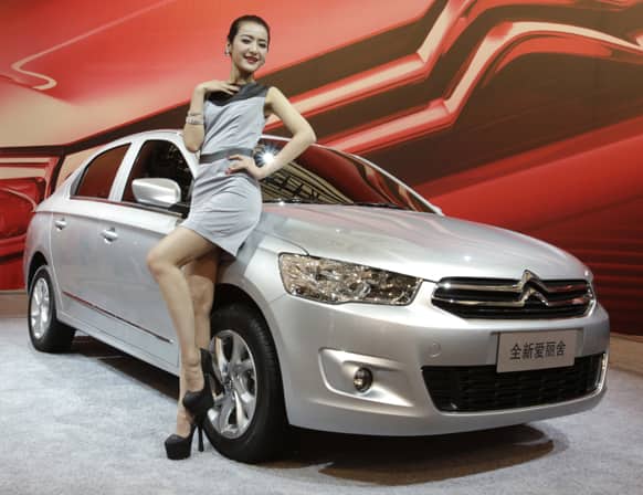 A model poses with a Peugeot C-Elysee displayed at the Shanghai International Automobile Industry Exhibition (AUTO Shanghai) in Shanghai, China.
