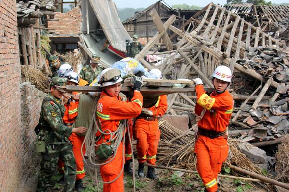 In this photo released by China`s Xinhua News Agency, rescuers carry out an elderly paralyzed person from a collapsed house after an earthquake struck, in Qingren Township, Lushan County, Ya`an City, southwest China`s Sichuan Province.