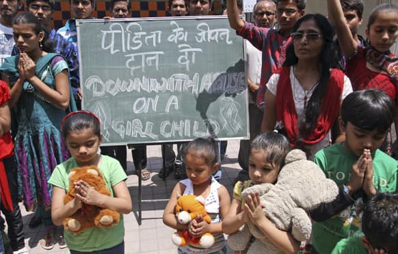 Young girls join others as they pray for the speedy recovery of a 5-year-old girl who was raped and tortured in Delhi.