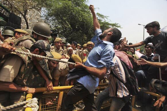 A protester shouts slogans while others run through a police barricade outside Delhi Police headquarters during a protest against the rape of a 5-year-old girl in New Delhi.