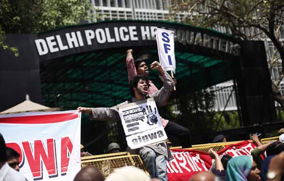 Protesters sit on a police barricade and shout slogans outside Delhi Police headquarters during a protest against the rape of a 5-year-old girl in New Delhi.