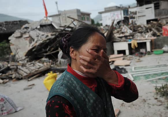 A village woman reacts after her house was damaged by an earthquake in Lushan county, Ya`an, southwest China`s Sichuan province.