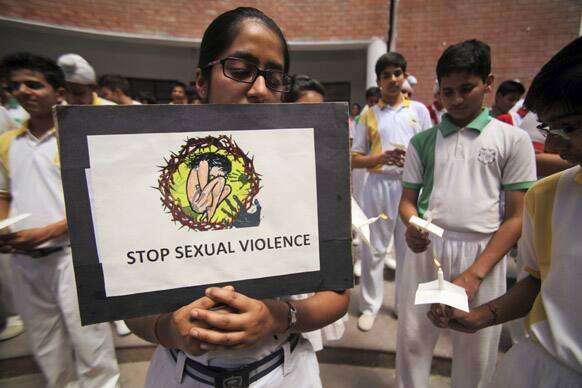 A student holds placard during a candle-light vigil for the speedy recovery of a 5-year-old girl who was raped and tortured in Delhi, at Heritage School in Jammu.