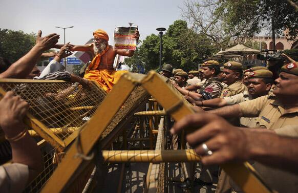 A Hindu holy man shouts slogans as he sits on police barricades outside Delhi Police headquarters during a protest against the rape of a 5-year-old girl in New Delhi.