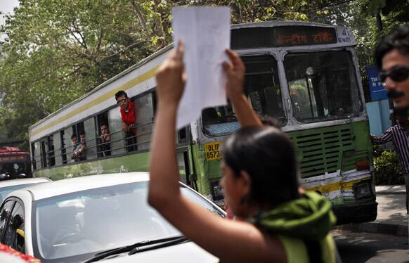 A girl holds a placard as she stops traffic outside Delhi Police headquarters during a protest against the rape of a 5-year-old girl in New Delhi.