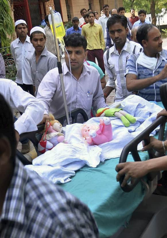 Stuffed toys lie in the body of a 5-year-old girl, according to police, being wheeled into a hospital for treatment after she was raped and tortured in New Delhi.