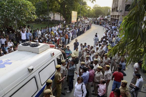 People watch an ambulance carrying a 5-year-old girl to a hospital for treatment after she was raped and tortured in New Delhi.