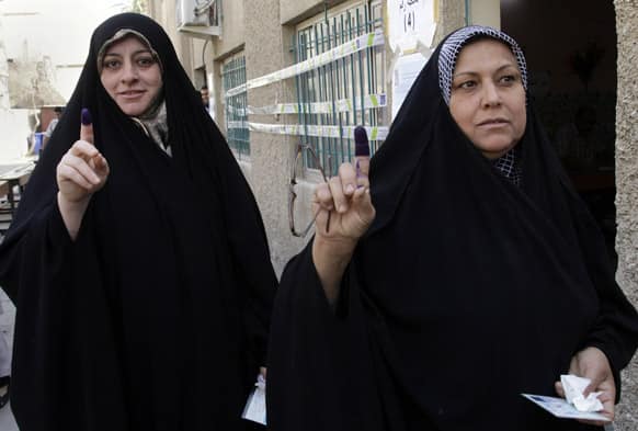 Iraqi women display their ink-stained fingers after voting in the country`s provincial elections in the country`s provincial elections in Baghdad, Iraq.