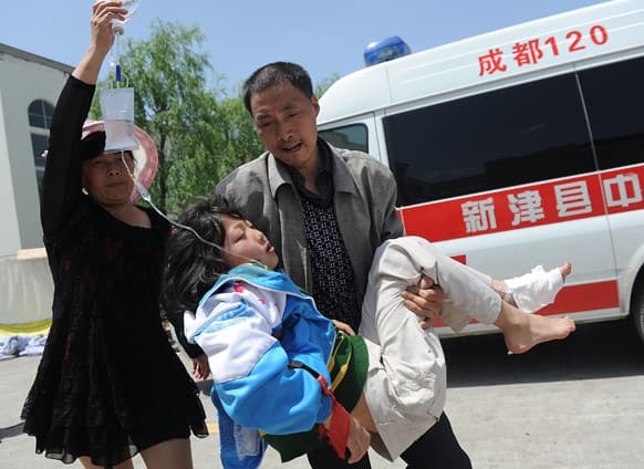 A man carries an injured woman to a temporary treatment station following an earthquake in Lushan county in Ya`an in southwest China`s Sichuan province.