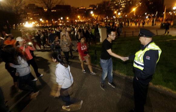 A line forms to shake the hand of officer Raymond Coldero, right, as a crowd reacts to news of the arrest of one of the Boston Marathon bombing suspects during a celebration at Boston.