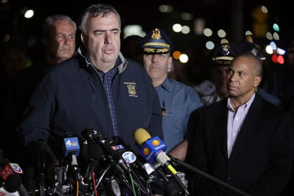 Boston Police Commissioner Ed Davis, at podium, speaks while accompanied by State Police Col. Timothy Alben, second from right, and Massachusetts Governor Deval Patrick, right, during a news conference, after the arrest of a suspect of the Boston Marathon bombings in Watertown.