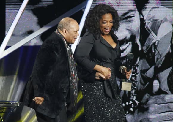 Oprah Winfrey, right, leads Quincy Jones, left, on the stage after speaking to induct him into the Rock and Roll Hall of Fame during the Rock and Roll Hall of Fame Induction Ceremony at the Nokia Theatre.