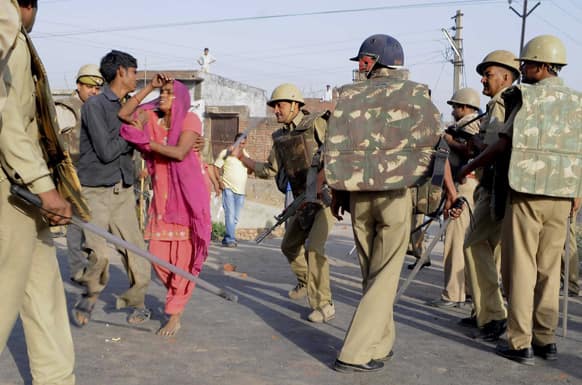 A policeman beats an elderly woman with a baton during a protest against the alleged rape of a six-year-old in Aligarh, in the northern Indian state of Uttar Pradesh.