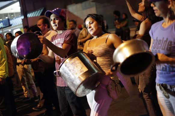 Opposition supporters bang pots against President-elect Nicolas Maduro as they protest the results of the presidential election in Caracas, Venezuela.