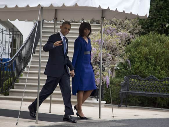 Barack Obama, accompanied by Michelle Obama, waves to media as they leave the White House to board the Marine One helicopter, en route to Andrews Air Force Base and onto Boston where they will attend a service dedicated to those who were gravely wounded or killed in the bombing.