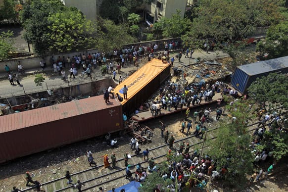 Bangladeshi people gather after three carriages of a container train derailed with one of the containers slamming into an adjacent slum in Dhaka. One person died and at least five were injured in the incident, police said.