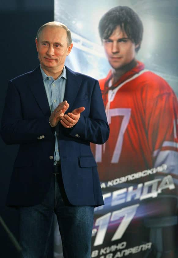 Russian President Vladimir Putin applauds after the premier of the movie