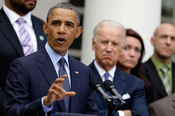 President Barack Obama, next to Vice President Joe Biden, gestures as he speaks during a news conference in the Rose Garden of the White House, in Washington.