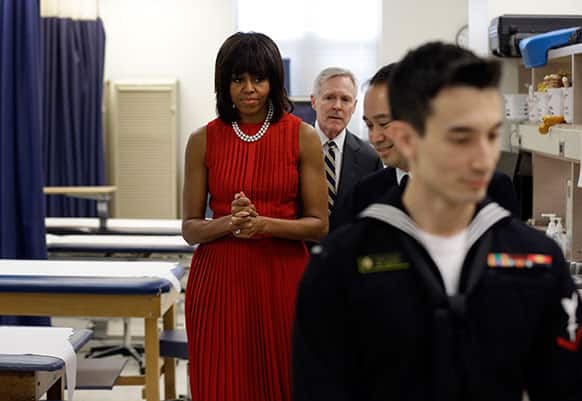 First lady Michelle Obama and Navy Secretary Ray Mabus, back, tour an orthopedic room with midshipmen at the US Naval Academy in Annapolis, Md.