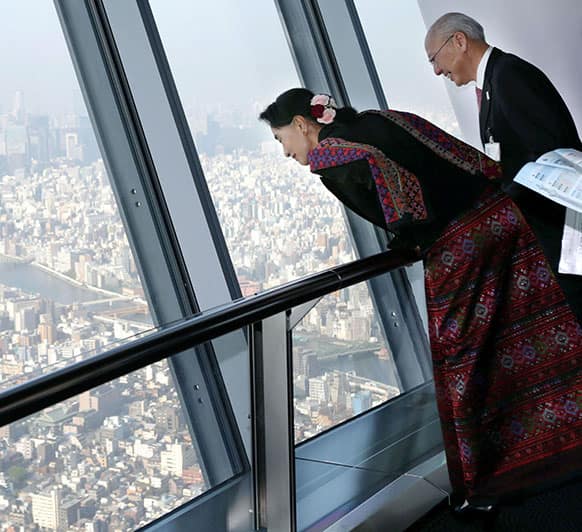 Myanmar opposition leader Aung San Suu Kyi, left, views from the 350 meters(382 yards)-high observation deck at the Tokyo Skytree in Tokyo.