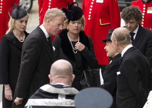 Britain`s Queen Elizabeth II, third from right, speaks with Carol Thatcher, center, and Mark Thatcher, second from left, the children of former British Prime Minister Margaret Thatcher, outside St. Paul`s Cathedral, in central London.