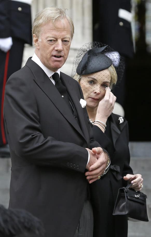 Mark Thatcher, looks on as his wife Sarah wipes her eyes after the coffin of his mother, former British Prime Minister Margaret Thatcher was carried by pallbearers out from St Paul`s Cathedral, following the ceremonial funeral service in London.