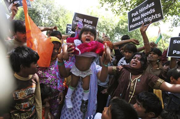 A Pakistani Hindu woman flails her daughter in the air during a protest against alleged human rights violations in Pakistan, outside the United Nation office in New Delhi.