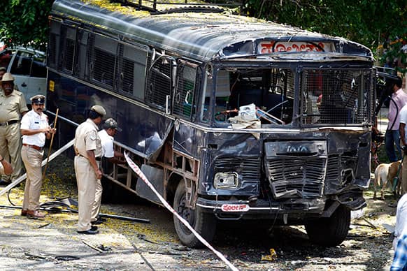 Policemen secure the area around a damaged police bus after an explosion in a residential neighborhood near the office of India`s main opposition Bharatiya Janata Party, in Bangalore.