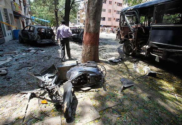 An official walks past charred vehicles after an explosion at a residential neighborhood near the office of India`s main opposition Bharatiya Janata Party in Bangalore.